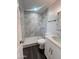 Updated bathroom featuring a walk-in shower with white stone tile and modern vanity sink at 3934 W Windsor Ave, Phoenix, AZ 85009