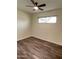 A bedroom featuring wood laminate flooring, a window and a ceiling fan with light fixture at 3934 W Windsor Ave, Phoenix, AZ 85009