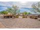 Large backyard features mature trees, gravel ground cover, a hay wagon, and space for activities at 39642 N Oxford Way, San Tan Valley, AZ 85140