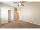 Neutral carpeted bedroom boasts a walk-in closet, fan and bright light at 39642 N Oxford Way, San Tan Valley, AZ 85140