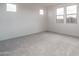 An empty bedroom with carpeted floors and multiple windows providing ample natural light at 4022 S 178Th Ln, Goodyear, AZ 85338