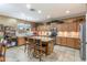 Well-lit kitchen with wooden cabinetry, a kitchen island, and stainless steel appliances at 42829 W Wild Horse Trl, Maricopa, AZ 85138