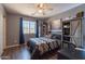 This bedroom has a ceiling fan, window, and a dark shelving unit with sliding barn doors at 5445 S 239Th Dr, Buckeye, AZ 85326