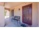Covered front porch featuring a decorative security door and a charming bench at 5445 S 239Th Dr, Buckeye, AZ 85326