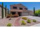 Inviting two-story home with desert landscaping, beautiful flowers, and a tile roof at 5445 S 239Th Dr, Buckeye, AZ 85326