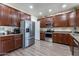 Stylish kitchen with stainless steel appliances, dark wood cabinets, and wood-look floors at 5445 S 239Th Dr, Buckeye, AZ 85326