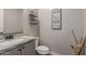 Charming powder room features stone countertop vanity and decorative wall art at 7442 W Redbird Rd, Peoria, AZ 85383