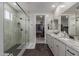 Luxury bathroom featuring a glass shower, dual sinks, and a walk-in closet at 7442 W Redbird Rd, Peoria, AZ 85383