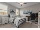 Comfortable bedroom with a black metal bed frame, ceiling fan, and adjacent home office at 7442 W Redbird Rd, Peoria, AZ 85383