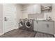 Efficient laundry room with gray cabinets, stainless steel appliances, sink and tile flooring at 7442 W Redbird Rd, Peoria, AZ 85383