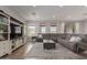 Bright living room featuring hardwood floors, a large sectional sofa, and ample natural light at 7442 W Redbird Rd, Peoria, AZ 85383