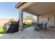 Charming covered patio with a dining table and a barbecue grill overlooking the serene backyard at 7442 W Redbird Rd, Peoria, AZ 85383