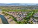 Aerial view of a neighborhood with lush green golf courses, scenic mountains, and a community lake at 7800 E Lincoln Dr # 1104, Scottsdale, AZ 85250