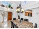 Bright dining room featuring a stone-topped table, stylish chandelier, and a peek into the kitchen at 7800 E Lincoln Dr # 1104, Scottsdale, AZ 85250