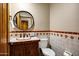 This bathroom features a wooden vanity, a round mirror, and floral-themed tile at 8540 E Mcdowell Rd # 19, Mesa, AZ 85207