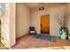 Inviting covered porch with a custom wood door, seating area and desert landscape at 8540 E Mcdowell Rd # 19, Mesa, AZ 85207