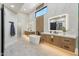 Spacious bathroom with modern vanities, sleek soaking tub, and neutral tile at 9159 N 108Th Pl, Scottsdale, AZ 85259