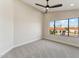 Bright bedroom featuring a modern ceiling fan, large window, and textured accent wall at 9159 N 108Th Pl, Scottsdale, AZ 85259