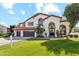 Two-story home showcasing a tile roof, three-car garage, arched entryway, and verdant lawn with a real estate sign at 9159 N 108Th Pl, Scottsdale, AZ 85259