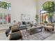 Bright living room with a soaring arch window, hardwood floors, contemporary furnishings, and stylish lighting at 9159 N 108Th Pl, Scottsdale, AZ 85259