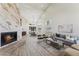 Open-concept living and dining area with soaring ceilings, a modern fireplace, hardwood floors, and stylish lighting at 9159 N 108Th Pl, Scottsdale, AZ 85259