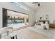Main bedroom with seating area, modern decor and large sliding glass doors leading to a private pool at 9159 N 108Th Pl, Scottsdale, AZ 85259