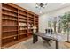 Home office with a built-in bookshelf, a modern desk, and a comfortable chair at 9159 N 108Th Pl, Scottsdale, AZ 85259