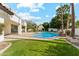 Beautiful backyard featuring a pool, grassy area, and covered patio at 9159 N 108Th Pl, Scottsdale, AZ 85259