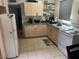 Galley kitchen with light wood cabinets, tile flooring and a white refrigerator and stove at 9804 N 5Th Ave, Phoenix, AZ 85021