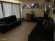Living room with tile floors, dark couches and a large television on the wall at 9804 N 5Th Ave, Phoenix, AZ 85021