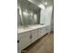 Elegant bathroom with double vanity sinks, white cabinets, and a large mirror reflecting a glass-enclosed shower at 10039 S 23Rd Dr, Phoenix, AZ 85041