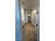 Bright hallway leading to bathroom with glass shower and modern vanity, showcasing a seamless design at 10039 S 23Rd Dr, Phoenix, AZ 85041