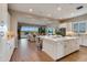 Bright kitchen open to the living room with a large island, sleek stainless steel appliances, and wood floors at 10039 S 23Rd Dr, Phoenix, AZ 85041