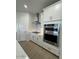 Modern kitchen features stainless steel appliances, sleek white cabinets and an oven at 10039 S 23Rd Dr, Phoenix, AZ 85041