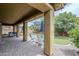 Covered back patio with brick pavers, seating area, and view of the landscaped backyard at 10249 E Kinetic Dr, Mesa, AZ 85212