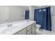 Bathroom with a dual sink vanity, a shower with a blue curtain, and a white door at 10249 E Kinetic Dr, Mesa, AZ 85212