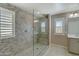 Modern bathroom with glass enclosed shower, pebble tile flooring, and shuttered windows at 10249 E Kinetic Dr, Mesa, AZ 85212