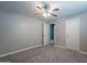 Neutral-toned bedroom featuring plush carpeting and a ceiling fan, providing a calming and comfortable space at 10249 E Kinetic Dr, Mesa, AZ 85212