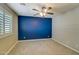 Bedroom showing blue accent wall, carpet and plantation shutters at 10249 E Kinetic Dr, Mesa, AZ 85212