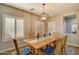 Bright dining area featuring a wooden table with seating for six, complemented by plantation shutters and modern lighting at 10249 E Kinetic Dr, Mesa, AZ 85212