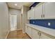 Hallway featuring built-in cabinets for storage, and an adjacent bathroom with a wood-look flooring at 10249 E Kinetic Dr, Mesa, AZ 85212