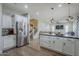 Open-concept kitchen with stainless steel refrigerator and island open to the living area at 10249 E Kinetic Dr, Mesa, AZ 85212