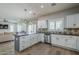Well-lit kitchen with white cabinetry, a large island, and stainless steel appliances at 10249 E Kinetic Dr, Mesa, AZ 85212