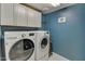 Laundry room featuring front loading washer and dryer, plus cabinet storage at 10249 E Kinetic Dr, Mesa, AZ 85212