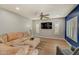 Bright living room with comfortable seating and a large TV, complemented by plantation shutters and a blue accent wall at 10249 E Kinetic Dr, Mesa, AZ 85212