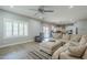 Bright living room featuring a comfortable sectional sofa, stylish rug and a ceiling fan at 10249 E Kinetic Dr, Mesa, AZ 85212