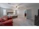 Spacious primary bedroom with a king bed, red leather sofa, and a view of the entertainment area at 10249 E Kinetic Dr, Mesa, AZ 85212