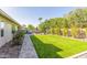 Lush backyard featuring manicured bushes, artificial grass, and pavers at 10410 E San Tan Blvd, Sun Lakes, AZ 85248