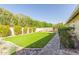 Landscaped backyard with artificial grass, a rock border, and a paver walkway at 10410 E San Tan Blvd, Sun Lakes, AZ 85248