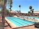 A large community pool with lounge chairs and umbrellas around the perimeter at 10410 E San Tan Blvd, Sun Lakes, AZ 85248